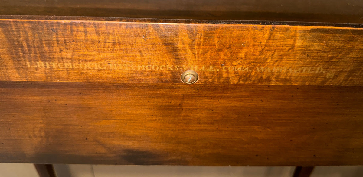 Close-up of a wooden drawer front with engraved text reading 'L.B.